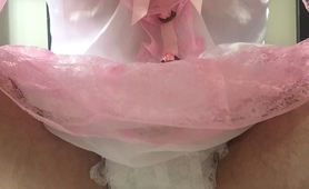 Sissy baby in a diaper and frilly dress